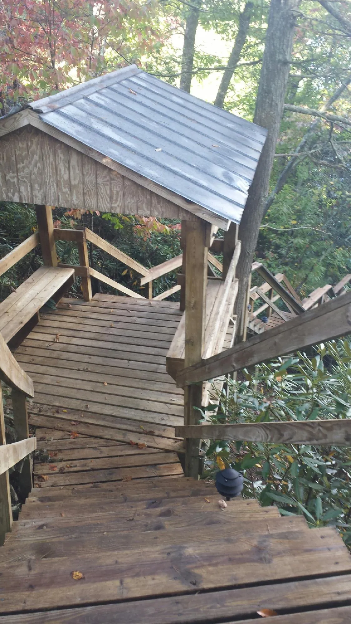 Metal roofed shelter over wooden steps on a wooded walkway — Skylight Repair & Installation work by our crew in Somerset